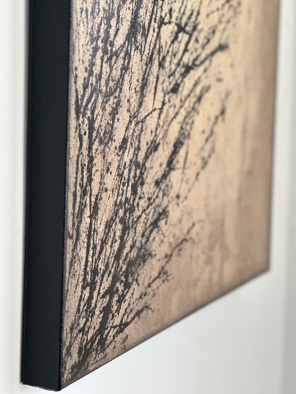 Entfaltung 1 - Abstract acrylic painting with dynamic black splatter pattern on beige canvas, side view mounted on wall