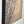 Entfaltung 1 - Abstract acrylic painting with dynamic black splatter pattern on beige canvas, side view mounted on wall